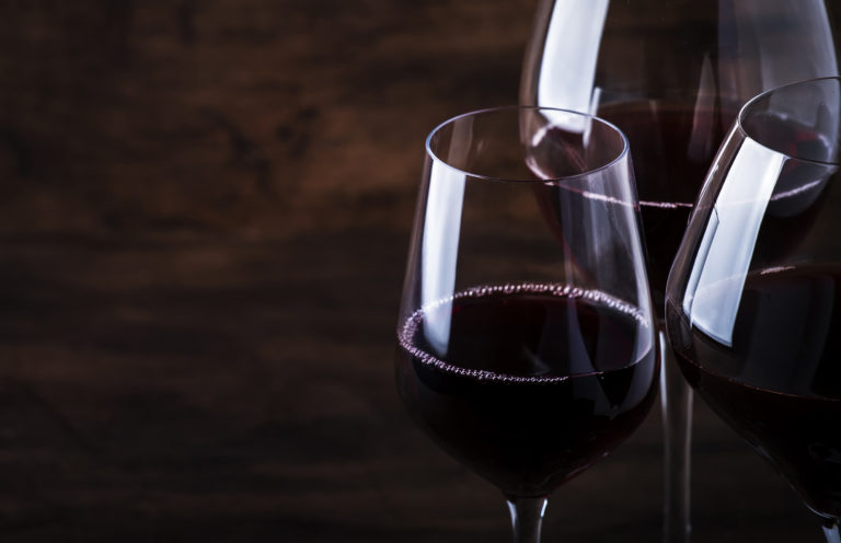 Wine glass. Selection of red wines on wine tasting. Dry, semi-dry, sweet red wine on old wooden table background. Copy space